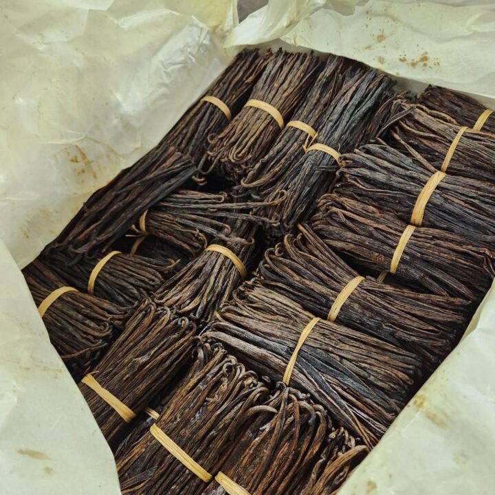 Vanilla beans tied into banded bundles and packed in paper inside an export carton